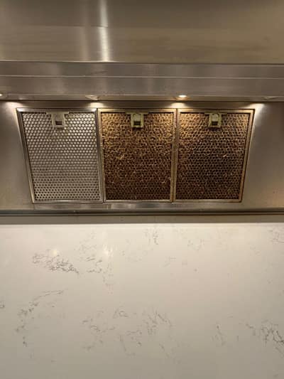 Cooker hood filters: one cleaned beside two still greasy