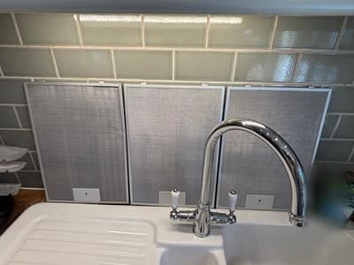 Cooker hood filters cleaned and laid out above the kitchen sink