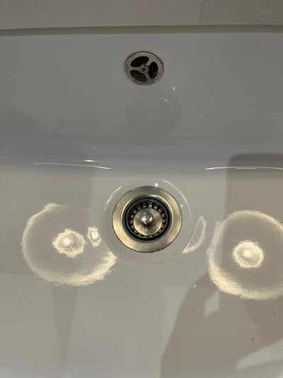 White ceramic sink and plughole after cleaning