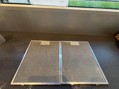 Clean cooker hood filters drying on a worktop