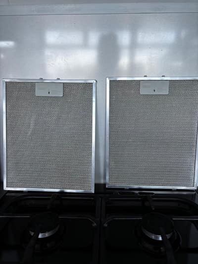 Clean cooker hood filters above a gas hob