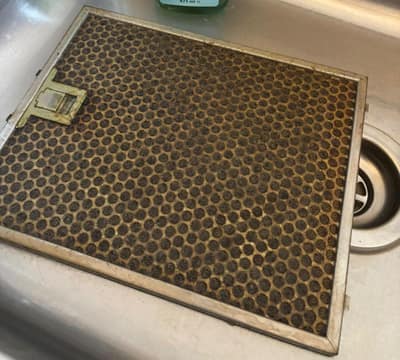 Cooker hood grease filter clogged with grease before cleaning